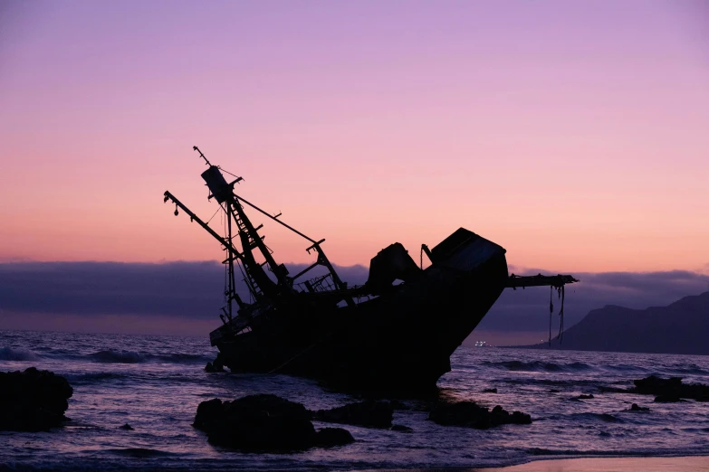 the boat is on top of rocks near the beach