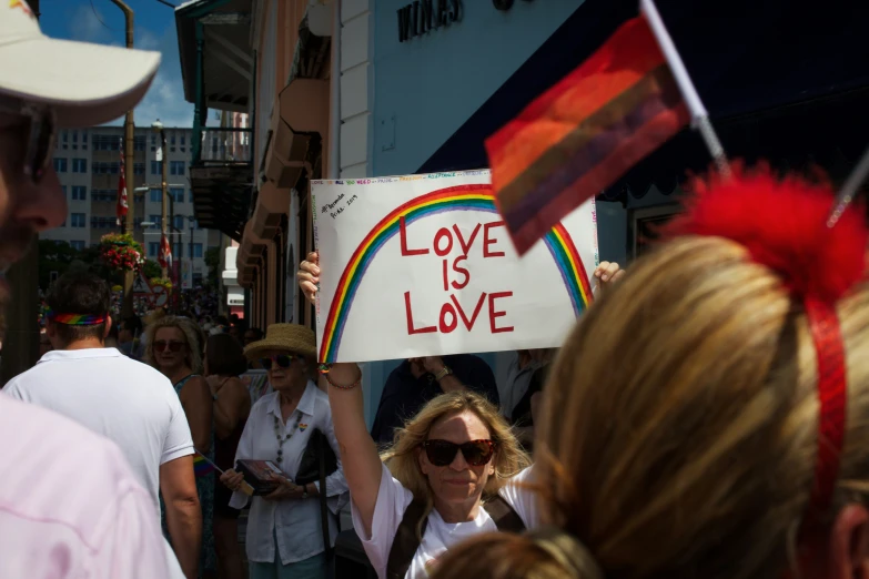 a man with sunglasses holds up a sign at an event