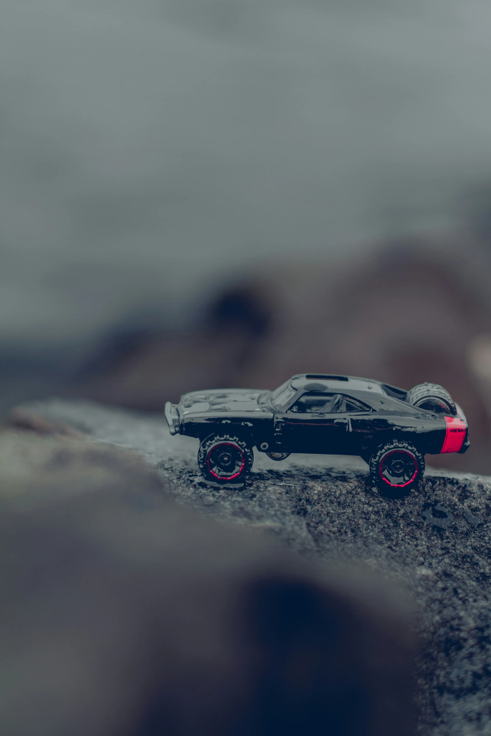 a toy car in motion on rocks on a cloudy day