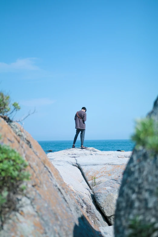 person standing on rock with ocean in the background