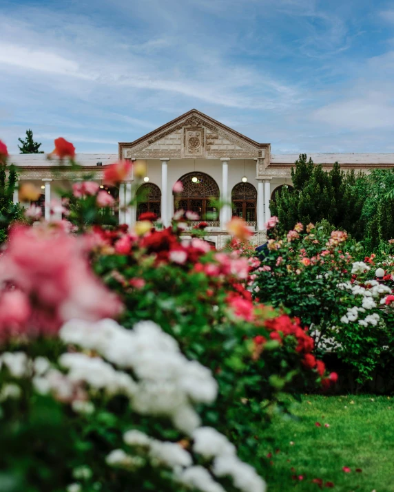 a mansion with lots of flowers around it