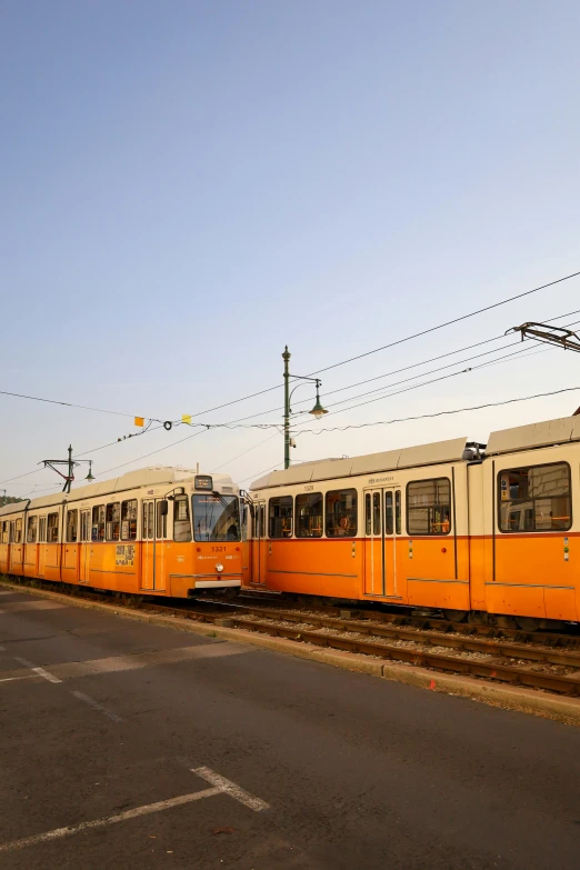 three orange train cars at the rail line