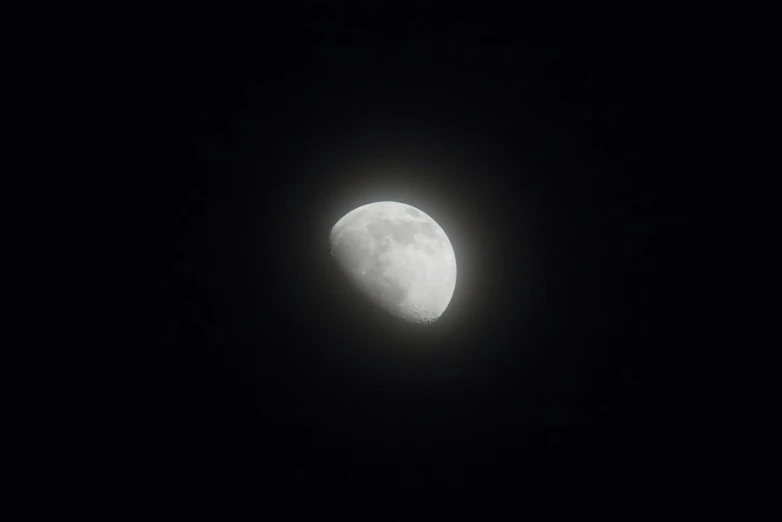 the full moon can be seen through the dark sky
