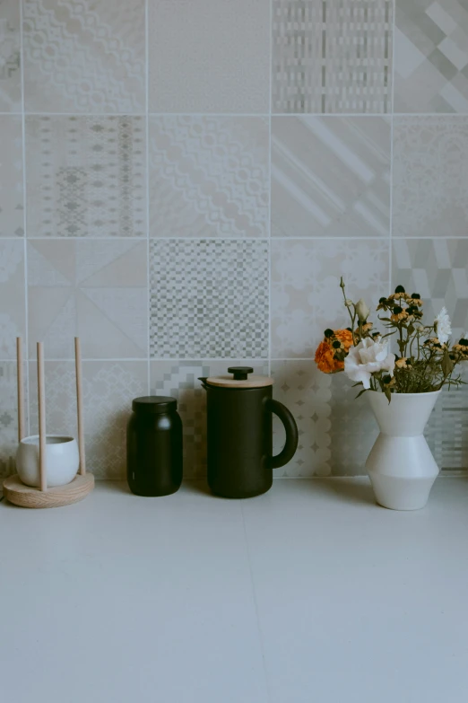 two cups are sitting next to a pitcher