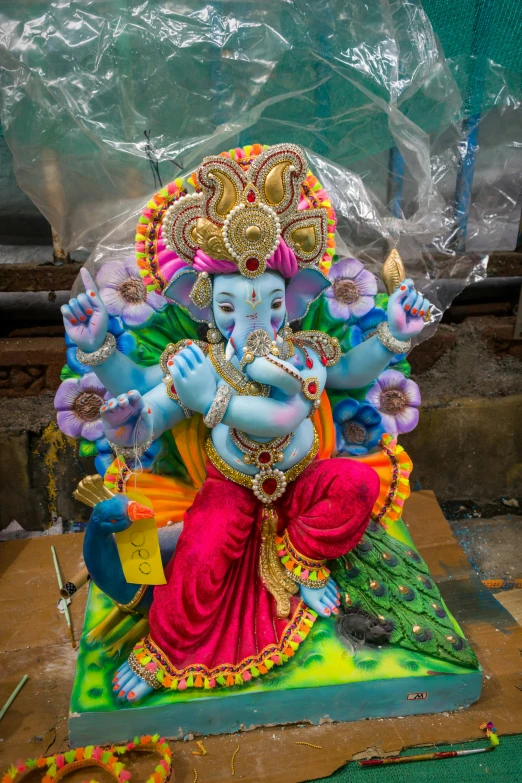 a statue of a lord ganpati with flowers around it's neck