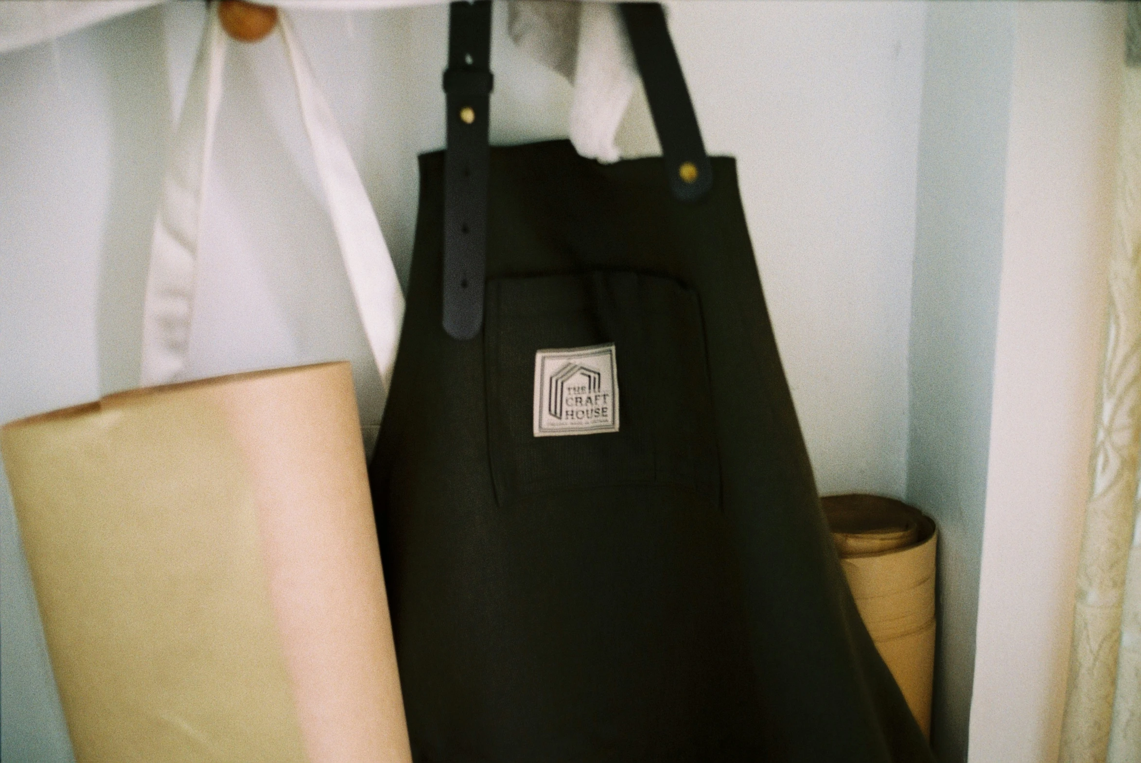 a black bag hanging next to an orange and white trash can