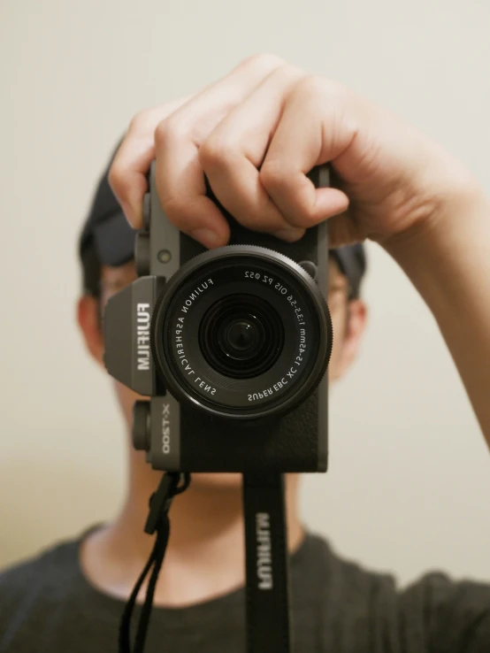 a man holding a camera up to the camera with his hands