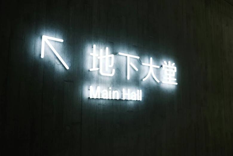 a white sign with the words main hall in english and asian