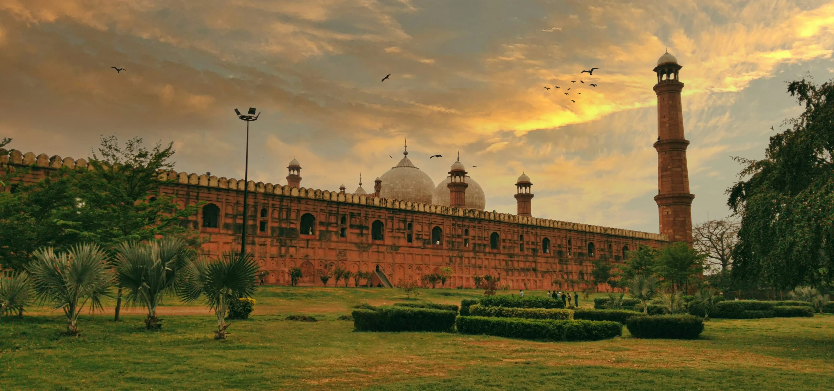 a red building with two domes and some trees