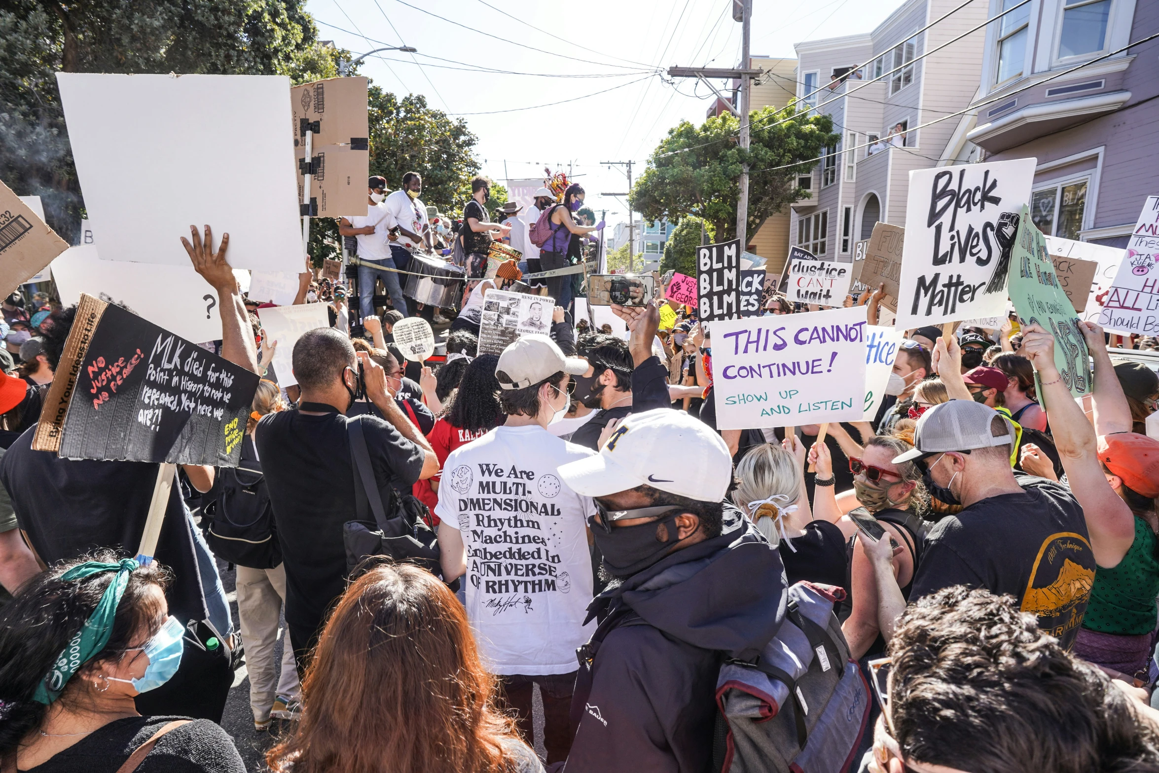 a group of people holding signs standing on top of a street