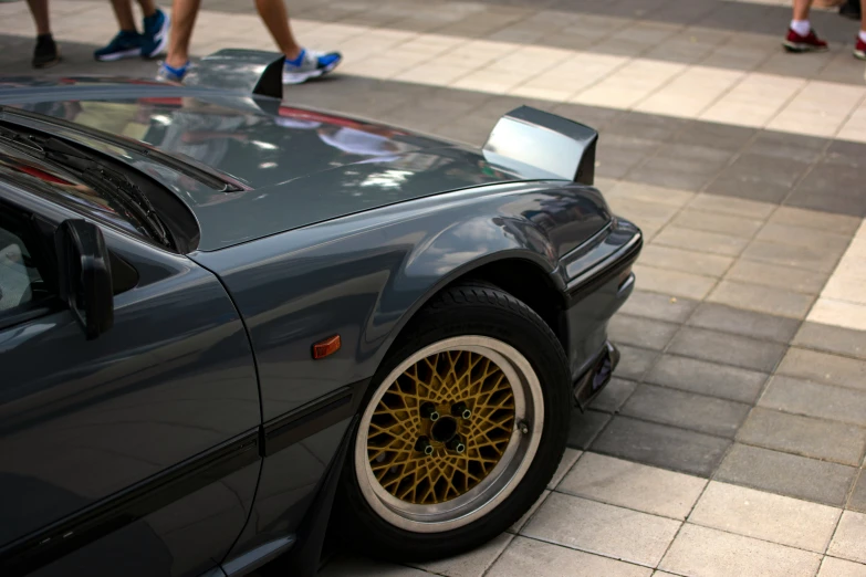 a gray sports car parked on the side of a street