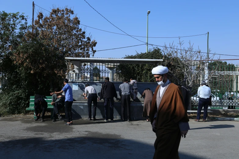 a man wearing a turban walks towards a public area