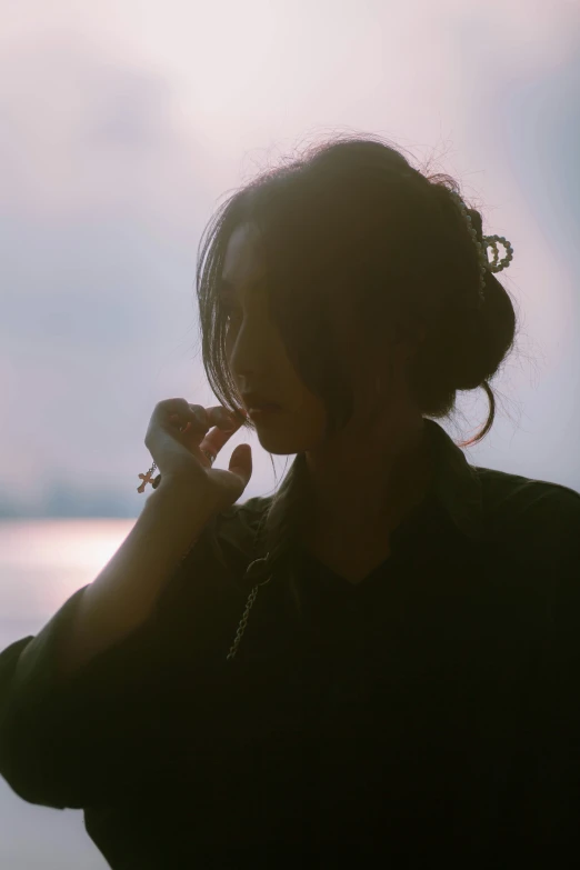 a young woman is standing by the water