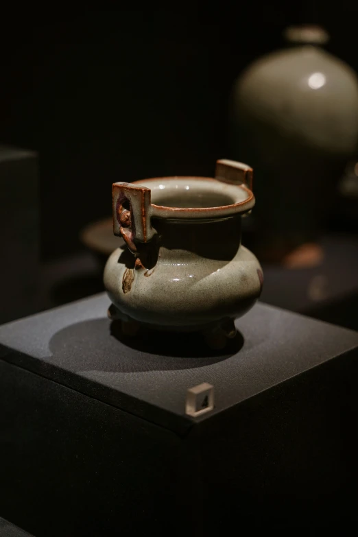 an empty vase is on a display shelf