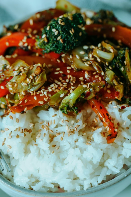 a plate of white rice with a sauce and vegetables