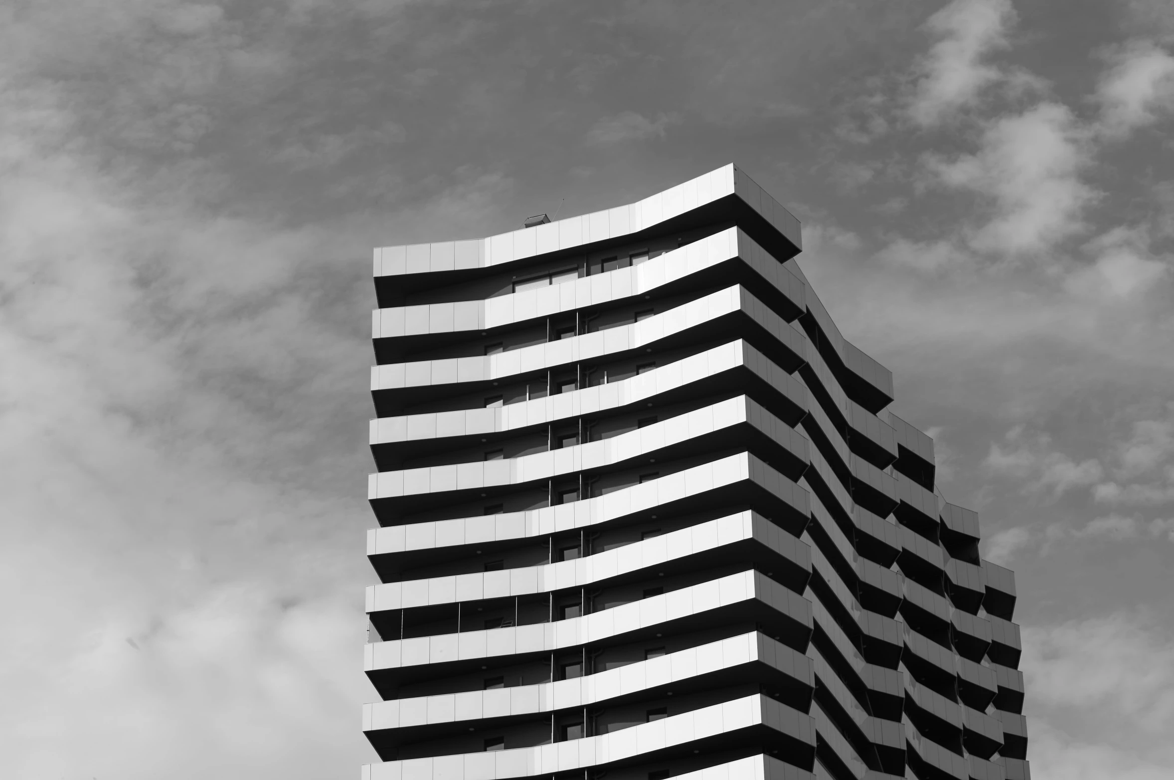 a very tall building sitting under a cloudy blue sky