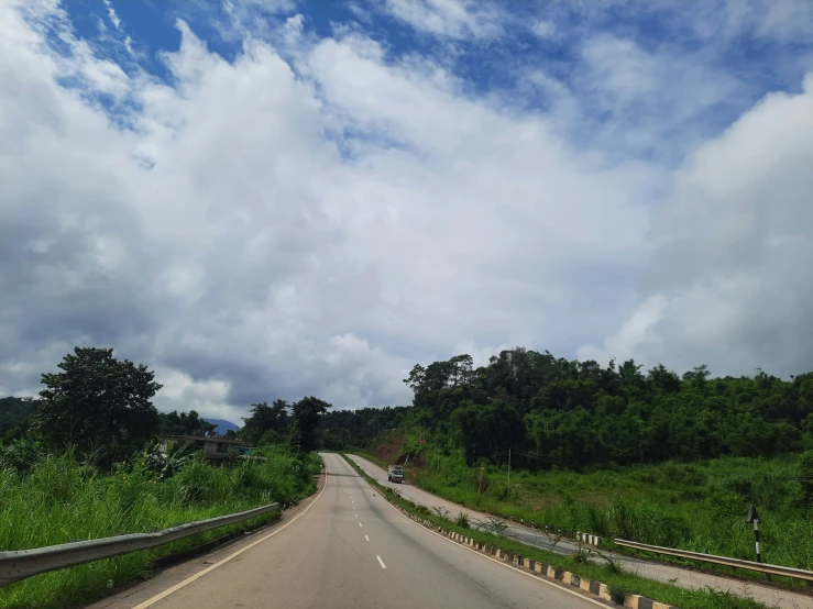 an empty road surrounded by trees and vegetation