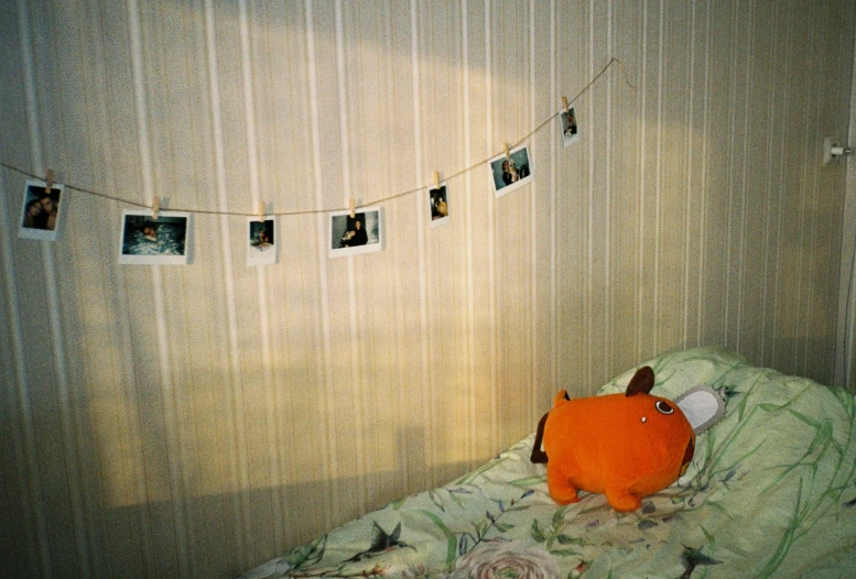 an orange teddy bear laying on top of a bed