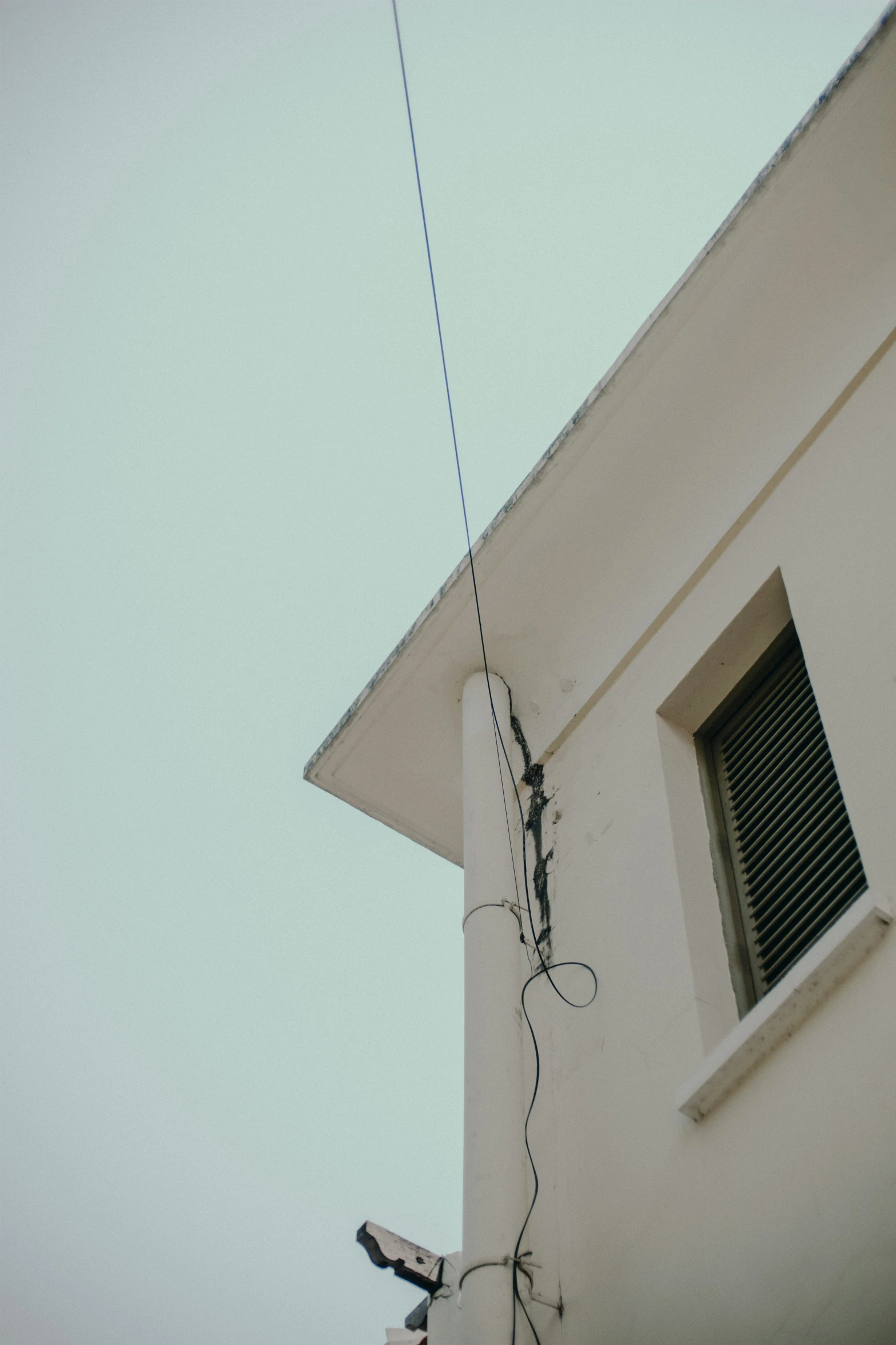 an old building with an electrical wire sticking out