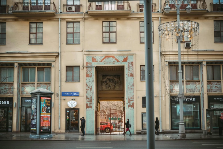 a woman stands outside a large building with an ornate doorway