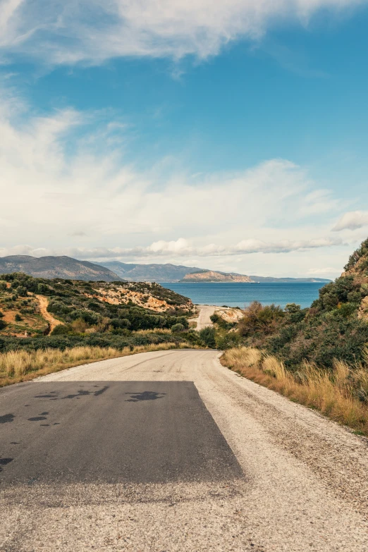 the view from a road that is surrounded by hills