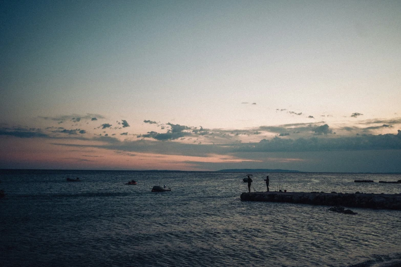 there is a boat out at sea at sunset