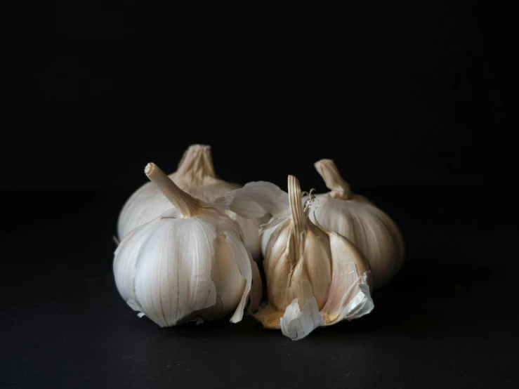 some garlic on a black surface with two heads