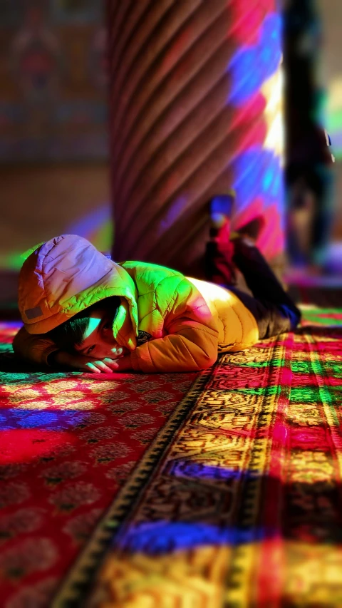 a woman laying on a colorful patterned rug