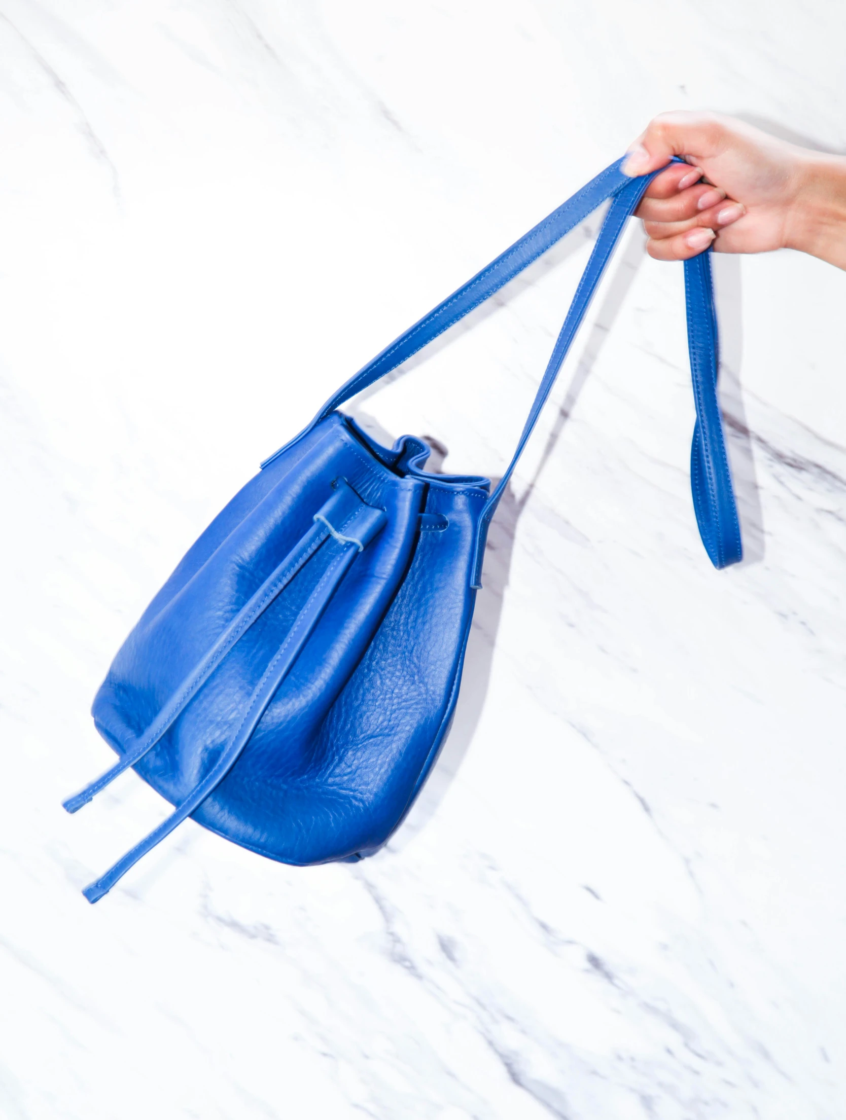 a blue purse being held by a hand