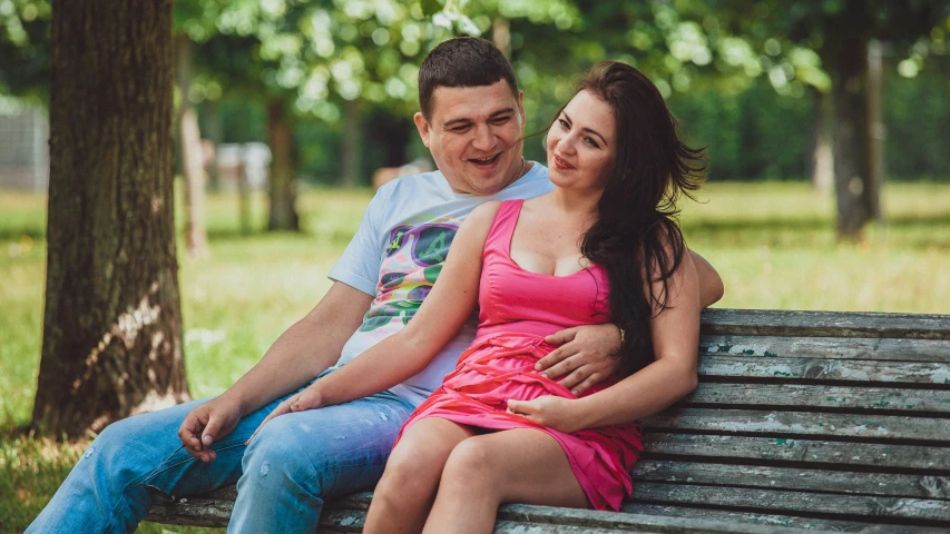 a man and woman sitting on a bench in the park