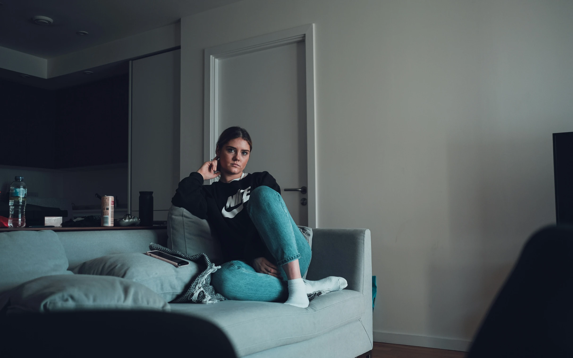 a beautiful young woman sitting on top of a couch