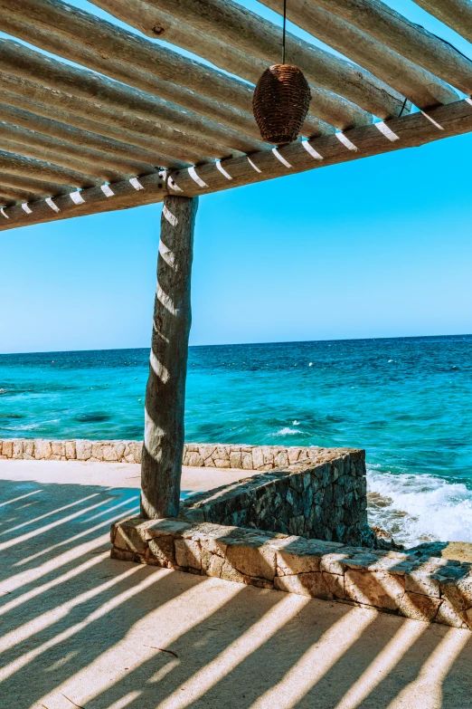 a bench sitting underneath a canopy next to a body of water