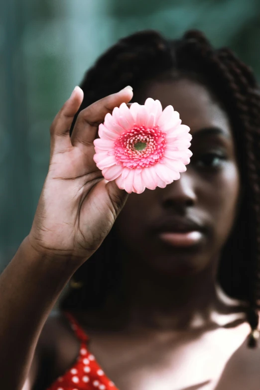 woman holding a flower in her hands with a blurry background