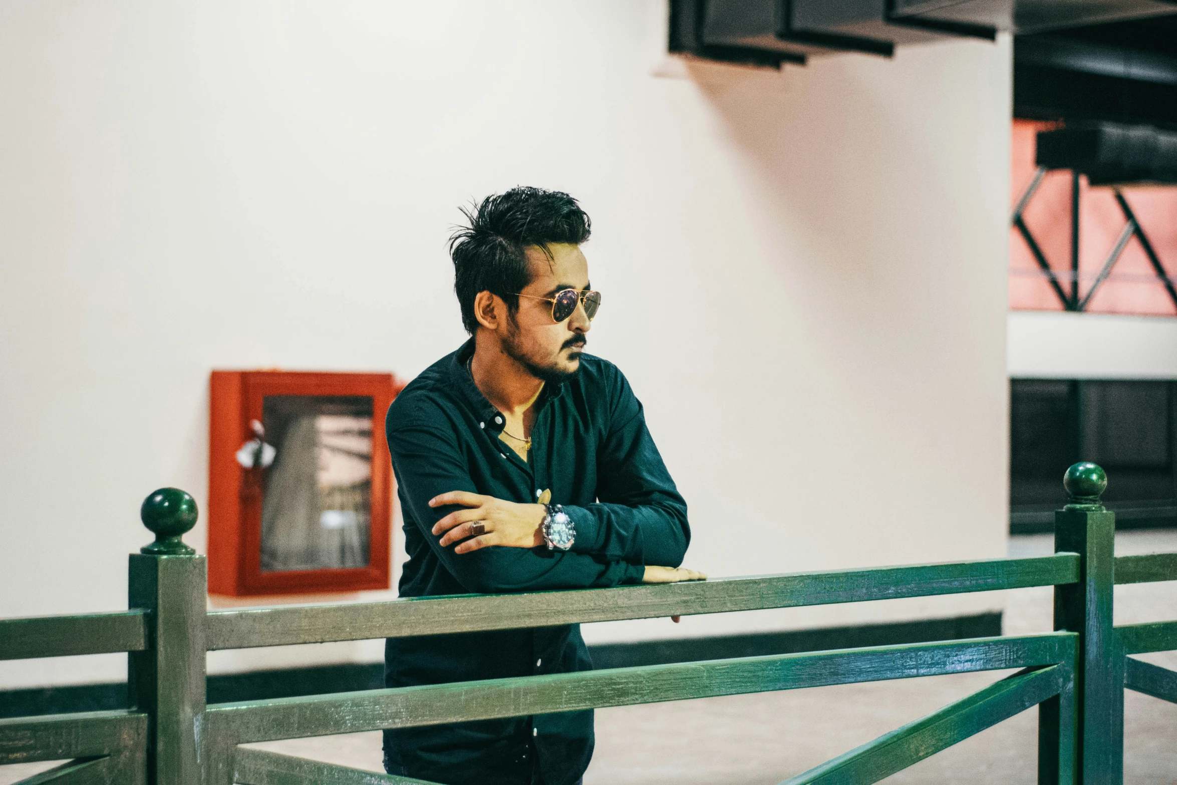 a man stands in a building wearing sunglasses