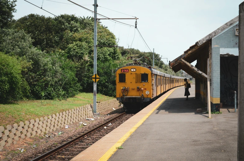 a yellow train traveling through a lush green countryside