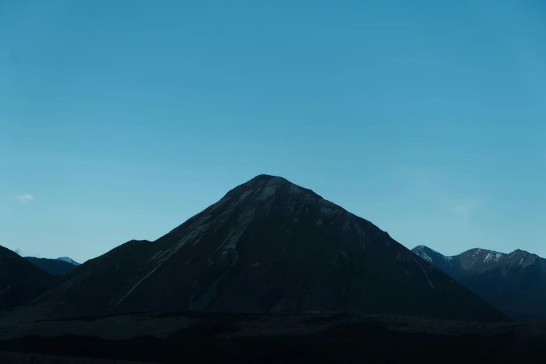 a distant, dark, low - hanging mountain peaks in the evening