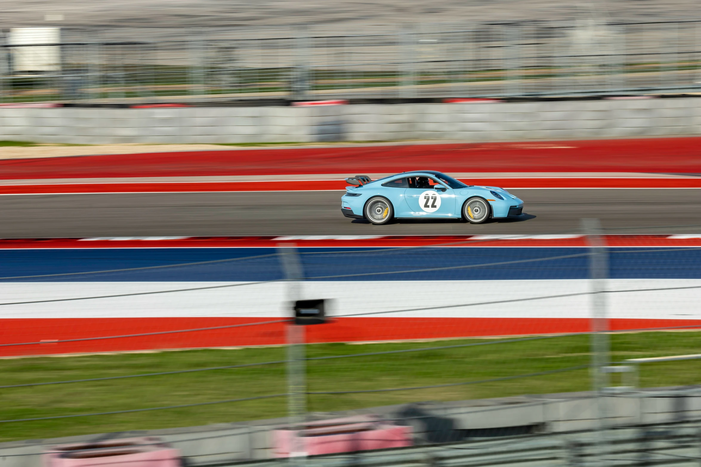 a blue sports car on an orange and white race track