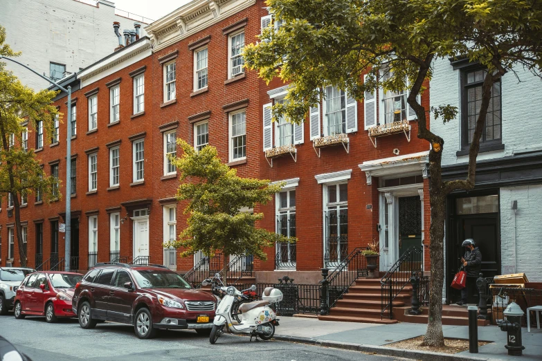 a person with a scooter stands near a fire hydrant on a sidewalk