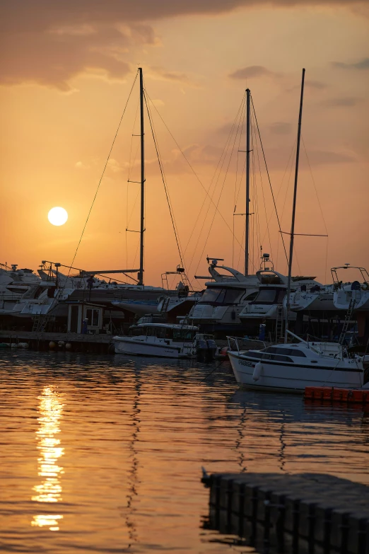 boats in the water with a setting sun behind them