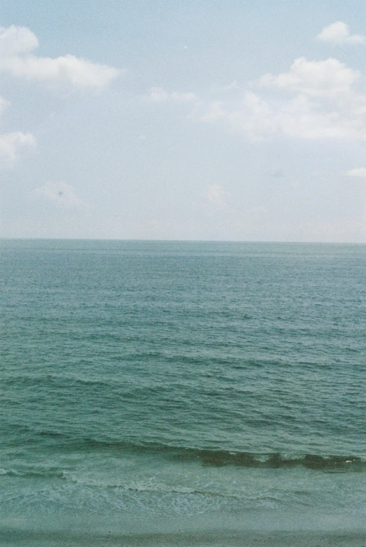 an ocean with very blue water and white clouds