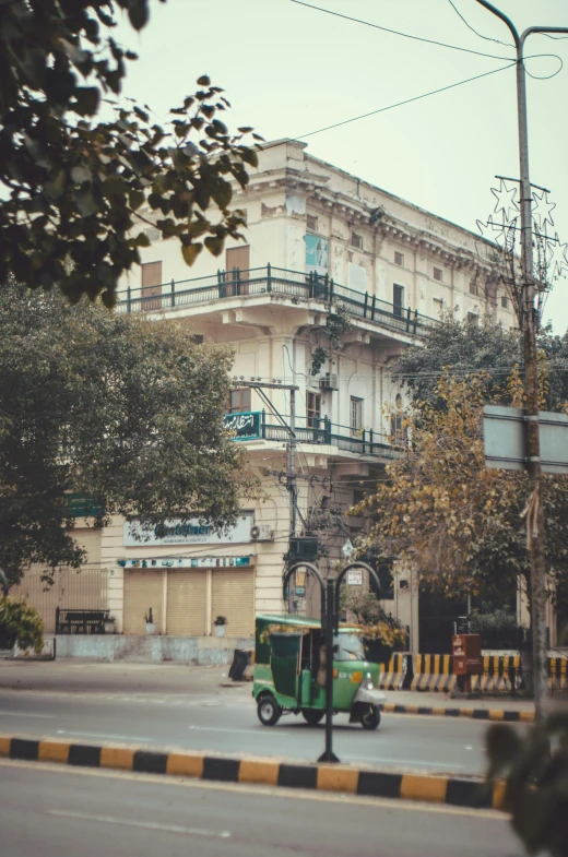 an old - fashioned truck driving past a tall building