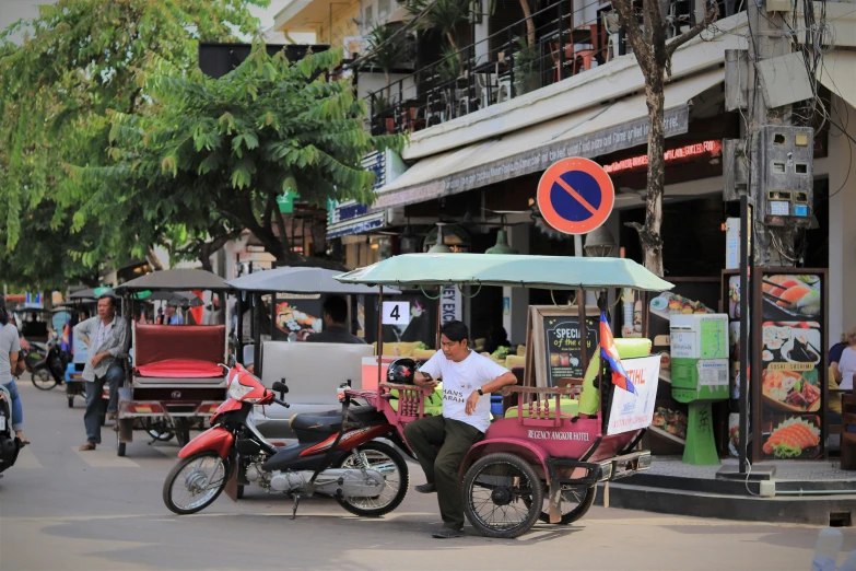 motorcycles parked next to people with umbrellas on the street