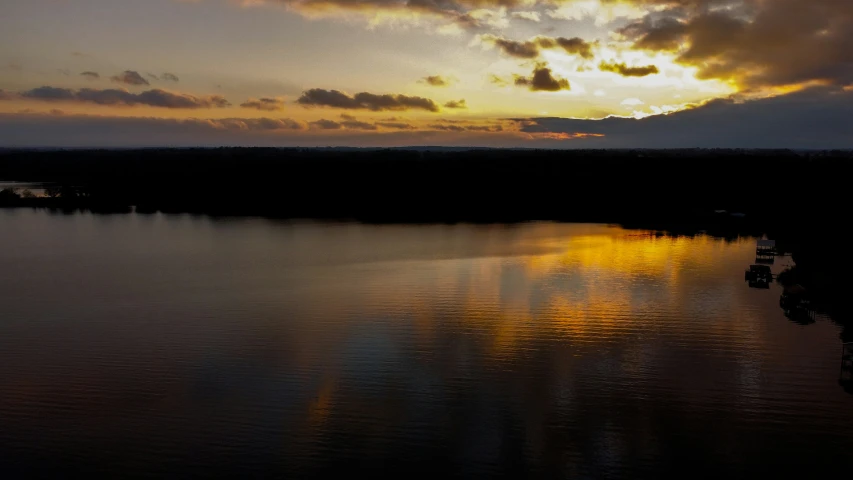 the sun is setting over some small boats