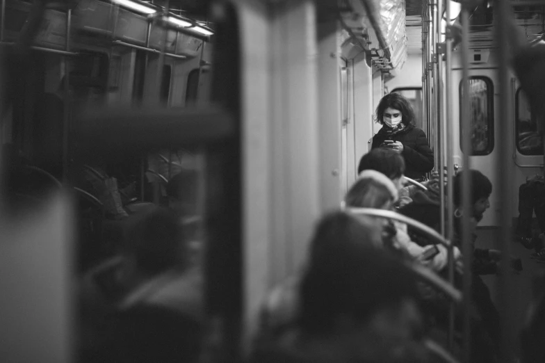 a woman with a cell phone on the subway