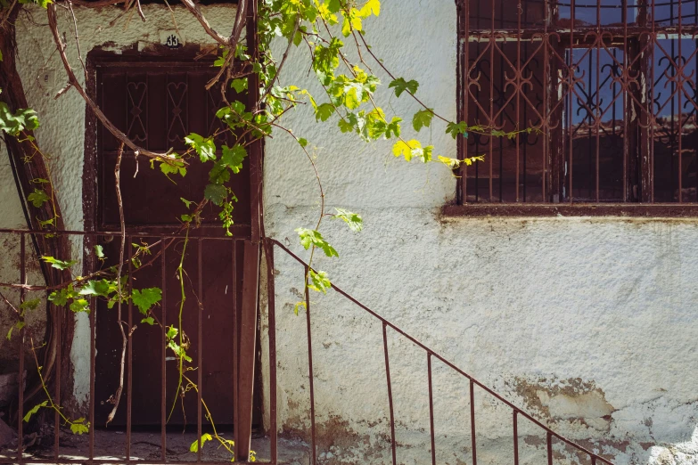 an old building with iron bars and stairs leading to it