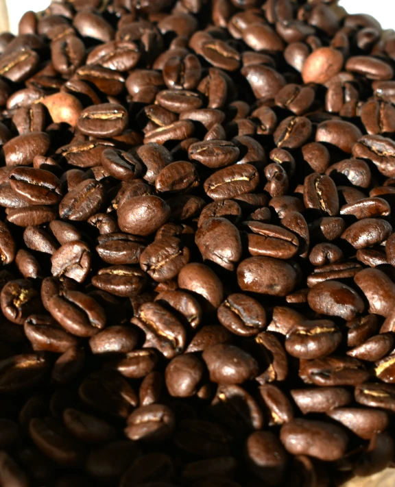 a pile of brown coffee beans sitting on top of a table