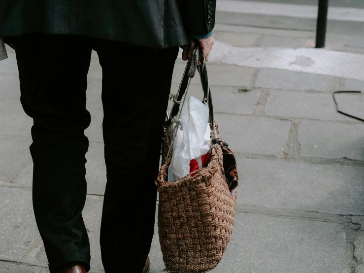 a person with a brown bag walking down a street