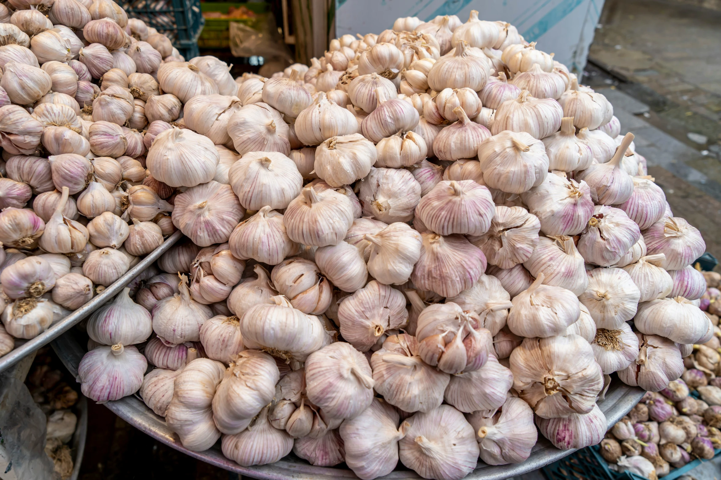 large bowls full of garlic on display in a market