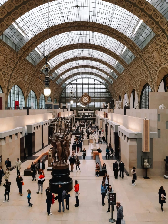 people standing inside a large building under a big ceiling