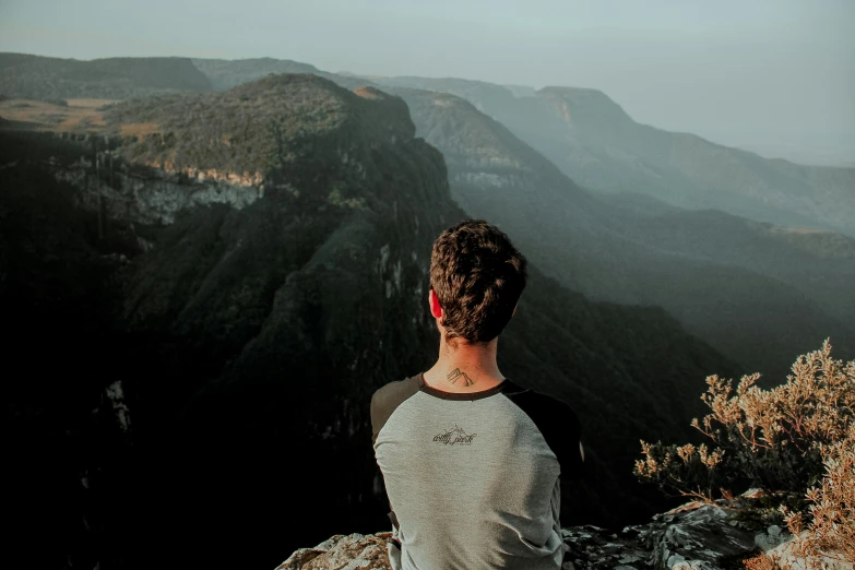 a man with a beard standing on the top of a hill